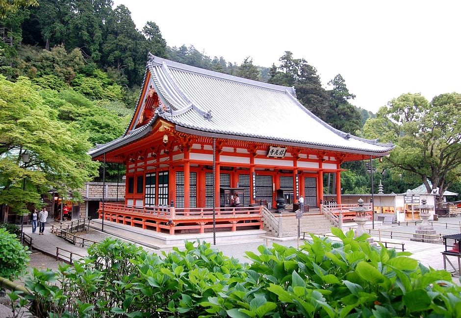Red main hall of Katsuoji Temple among forest greenery in Minoo, Osaka