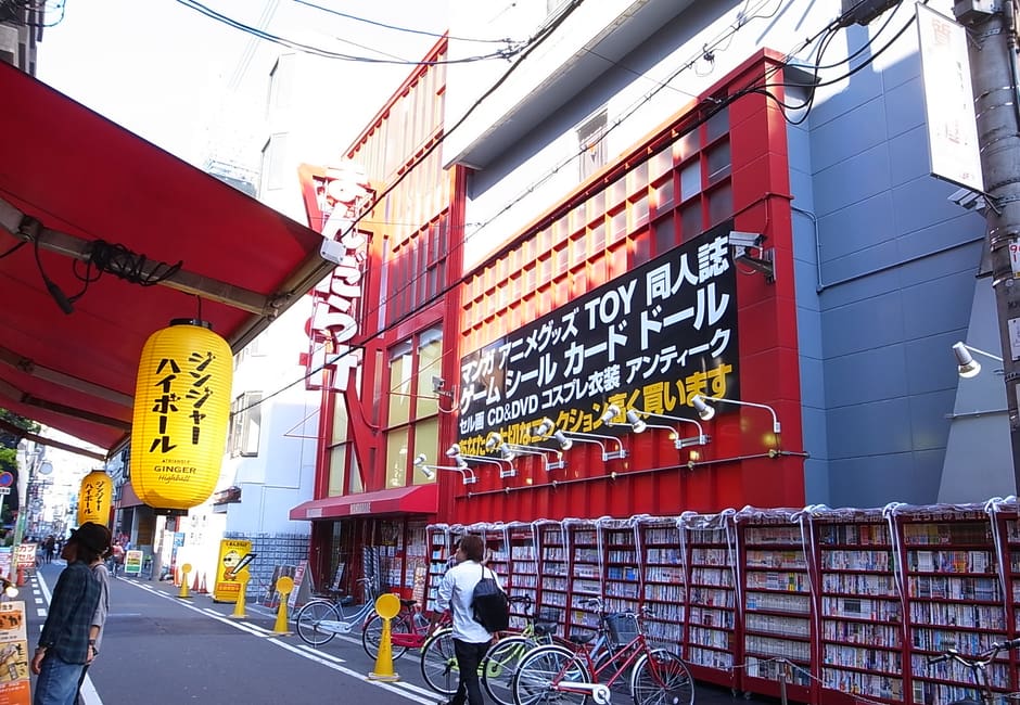 Red Mandarake shop front with signs on a street in Osaka