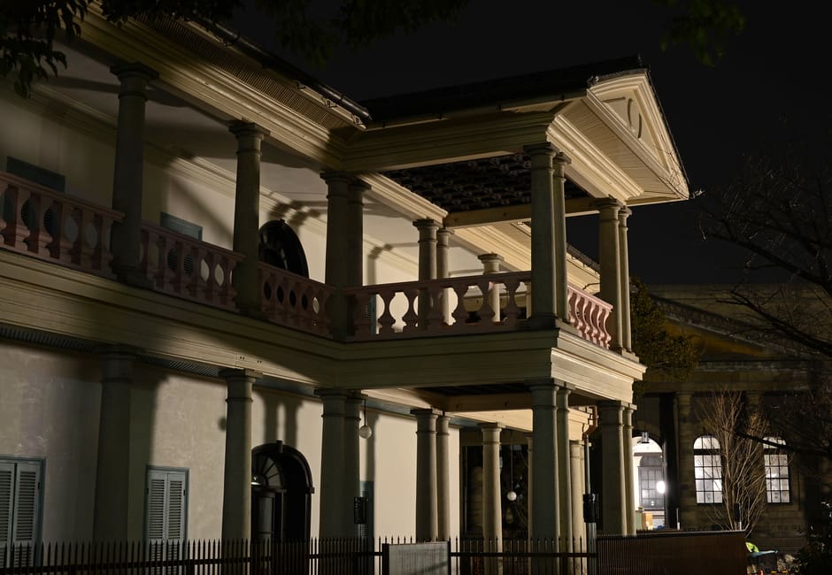 Neoclassical Senpukan building with columned veranda lit at night in Osaka