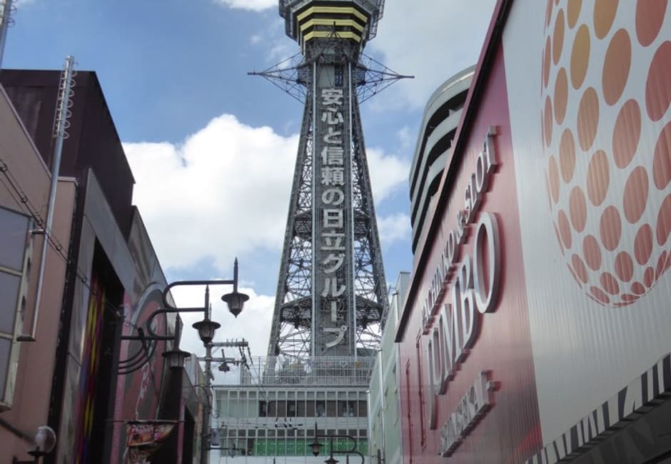 Tsutenkaku tower rising above the shop signs of Shinsekai in Osaka
