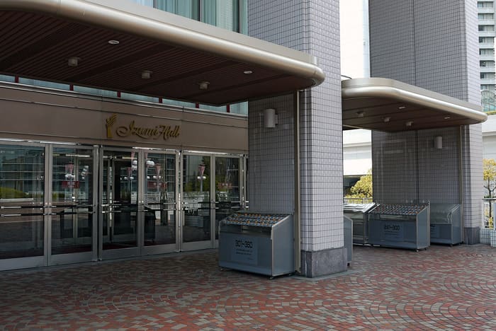 Entrance of Izumi Hall in Osaka with gold name sign above glass doors