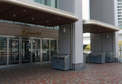 Entrance of Izumi Hall in Osaka with gold name sign above glass doors