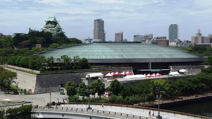Green glass roof of Osaka-jo Hall below the Osaka Castle keep, seen across the moat