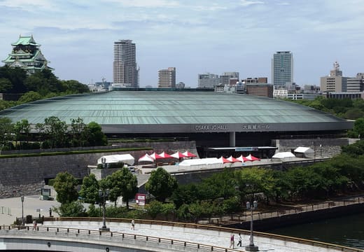 Green glass roof of Osaka-jo Hall below the Osaka Castle keep, seen across the moat